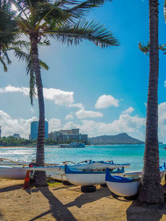 Canoes on a Hawaiian beach with Diamond Head Volcano in the backgroundの写真素材
