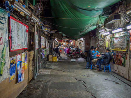 HONG KONG - NOVEMBER 9, 2014: Backstreet in Kowloon Hong Kong with locals people eatingのeditorial素材