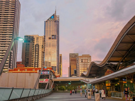 MELBOURNE, AUSTRALIA - JANUARY 29, 2016: Commuters walking on the pedestrian footbridge at Southern Cross Station in Melbourne. The view looks towards the CBD skyline, featuring the AMP building and Spencer Street during a soft sunset.のeditorial素材