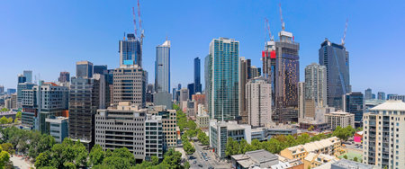 A wide panoramic aerial shot of the Melbourne city skyline, highlighting the construction boom with multiple cranes and new skyscrapers rising alongside established office towers.の写真素材
