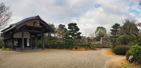 YAMATOKORIYAMA, NARA, JAPAN - JANUARY 29, 2020: A traditional building stands adjacent to the reconstruction site of the Gokuraku-bashi Bridge within the Koriyama Castle ruins. In the background, ladders are positioned against the historic stone walls as のeditorial素材