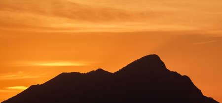 An orange sunset in the background
