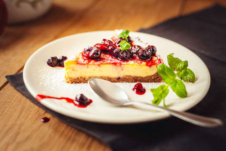 A side view of a cheesecake on a wooden floor with hazelnutsの写真素材