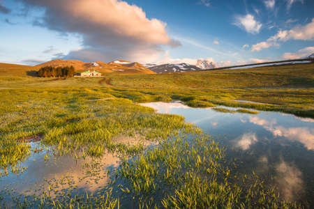 A beautiful view of a typical landscape in Campo Imperatore, Abruzzo. Rocks, grass and lakeの写真素材