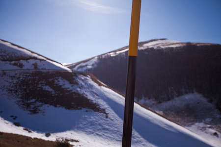 Road sign in the snow on the road to arrive in Castelluccio di Norcia, Umbria, Italy