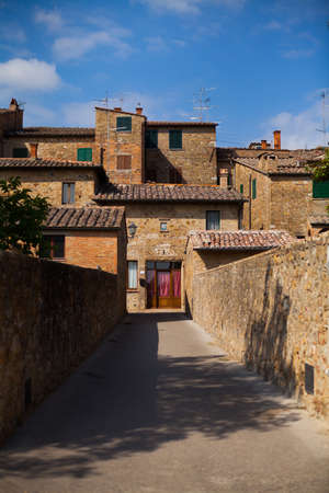 Alley with typical stone houses, San Quirico d'Orcia, Tuscany, Italy