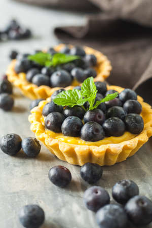 blueberries egg tart on wooden tableの写真素材