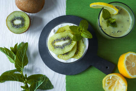 Homemade greek yogurt with kiwi, lemon and mint and healthy shack of kiwi, banana and lemonの写真素材