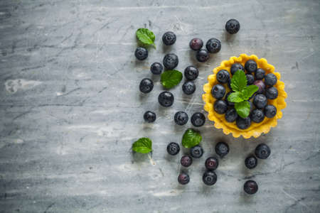 blueberries egg tart on the wooden table.の写真素材