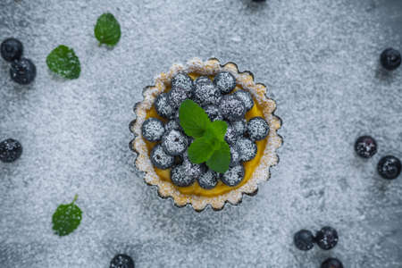blueberries egg tart on the wooden table.の写真素材