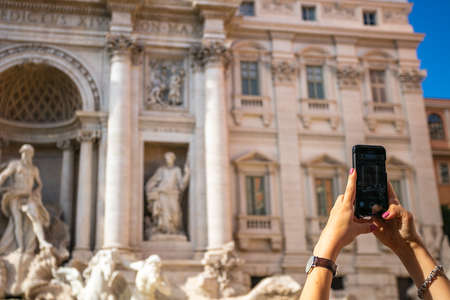 A girl is photographing the Trevi Fountain in Rome, Italyの写真素材