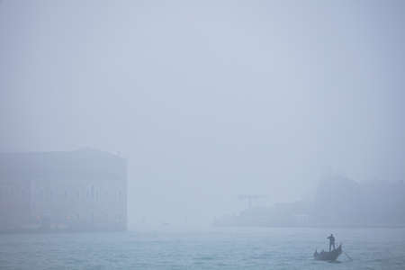 Gondolier sails on a gondola in the sea, Venice, Italyの写真素材