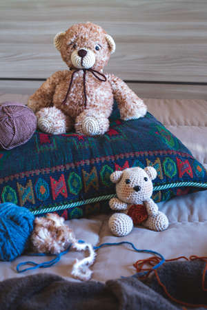 Cute wool teddy bear is lying in the bedの写真素材