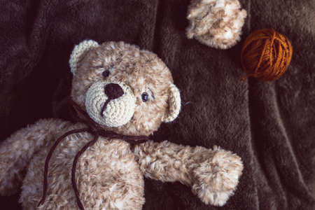Cute wool teddy bear is lying in the bedの写真素材