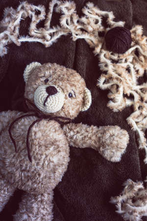 Cute wool teddy bear is lying in the bedの写真素材
