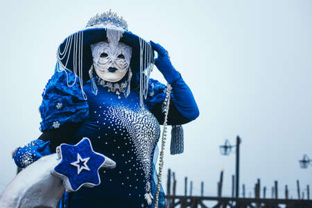 Portrait of a woman with a beautiful blue mask in Venice, Italyの写真素材