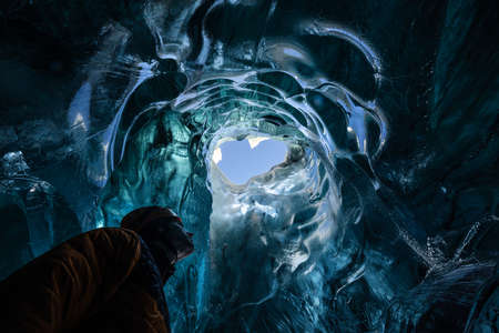 Explorer in the blue ice caves in JÃ¶kulsÃ¡rlÃ³n glacier, Iceland, North Atlantic Ocean