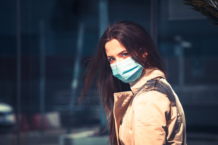 Girl with medical mask is staying in the city during pandemic of Coronavirus Covid-19の写真素材