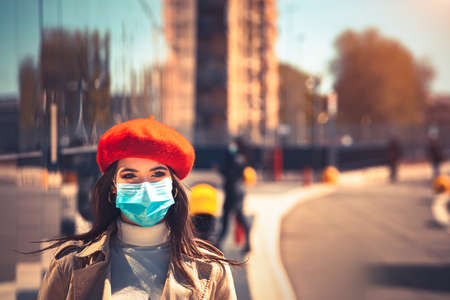 Girl with medical mask is walking in the city during pandemic of Coronavirus Covid-19の写真素材