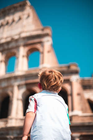 A young caucasian boy of about three years old wears a white t-shirt and visits the city of Romeの写真素材