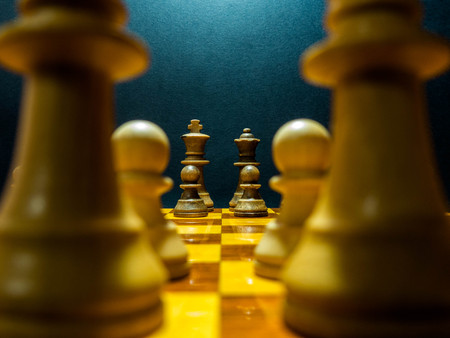 wooden chess pieces on a wooden chessboard in a dark backgroundの写真素材