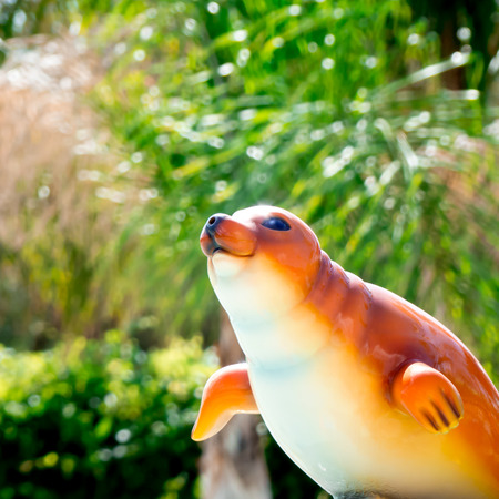 An orange seal toy on a green backgroundの写真素材