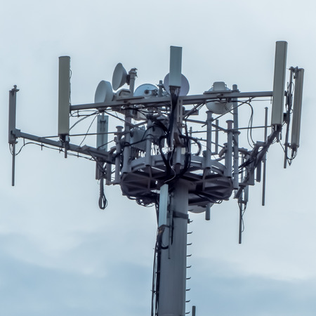 a telephone antenna with a cloudy sky backgroundの写真素材