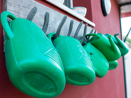 watering cans hanging on horsehoes in an italian farmの写真素材
