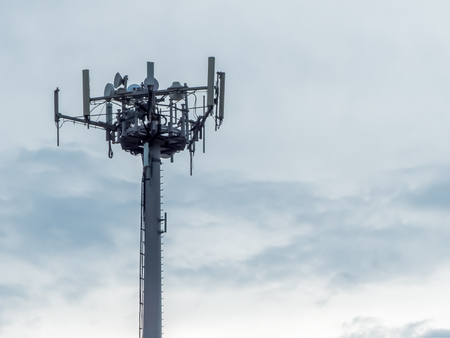a telephone antenna with a cloudy sky backgroundの写真素材