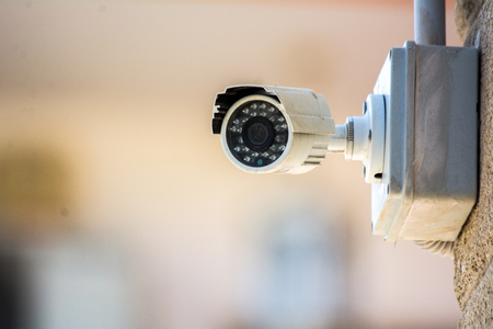 a surveillance camera placed on a wall on a blur backgroundの写真素材