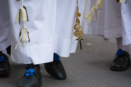 detail of the trditional dresses of christian confraternity members during a procession