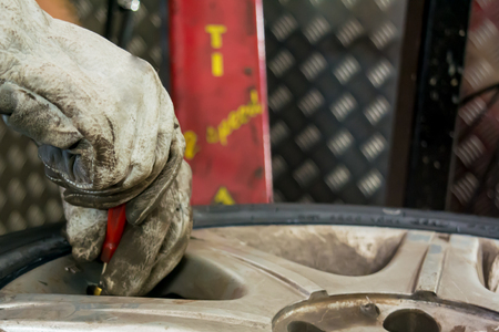 man changing the tire valve at the tire shopの写真素材