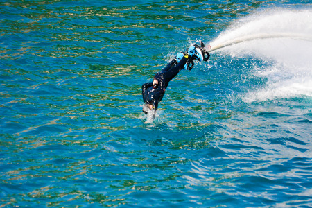 dolphin style during a flyboard show in the ionian sea on blur backgroundの写真素材