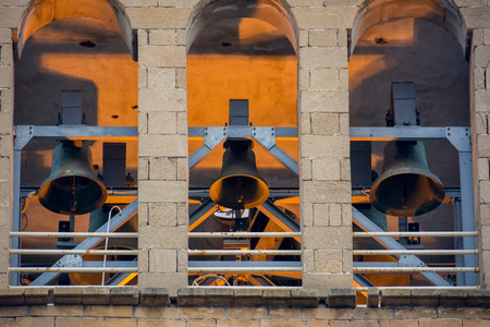 Frontal View Of Three Church Bells On Golden And Blue Lights Background