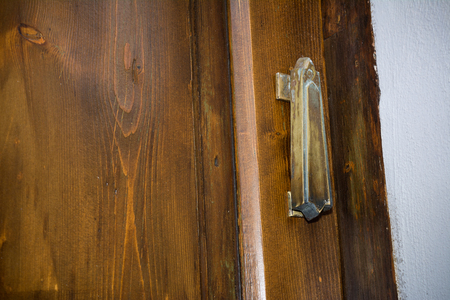 Horizontal View of a Close Up Of An Old Steel Clapper  On A Wooden Door. Matera, South of Italyの写真素材