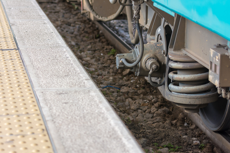 Horizontal View of Close Up of the Shock Absorbers of the Wheels of a Train Wagon Near the Dock at the Railway Station. Taranto, South of Italyの写真素材
