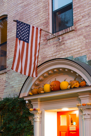 The American Flag on a Facade Decorated with Halloween Pumpkins during Halloween Celebrations in Georgetown. Washintgon, Virginiaの写真素材