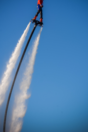Vertical View of Santa Claus on Flyboard on Blue Sky Backgroundの写真素材