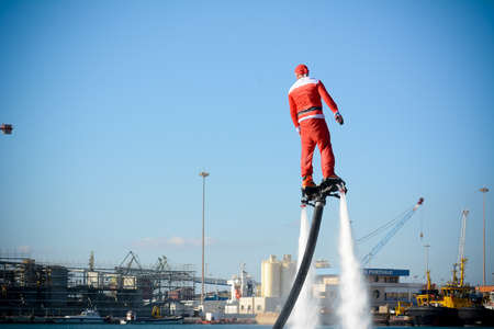 Horizontal View of Santa Claus on Flyboard on Blur Background. Taranto, Italyの写真素材