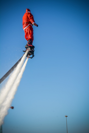 Vertical View of Santa Claus on Flyboard on Blue Sky Backgroundの写真素材