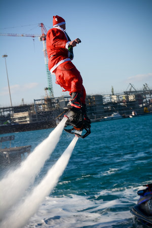 Vertical View of Santa Claus Flying on Flyboard on Blur Background. Taranto, Italyのeditorial素材