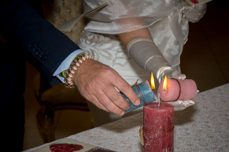 Hands of Married Lighting Candles during the Wedding Day on Blur Backgroundの写真素材