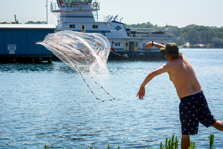 Man that Hand Launches the Fishnet at Sea on Blur Backgroundの写真素材