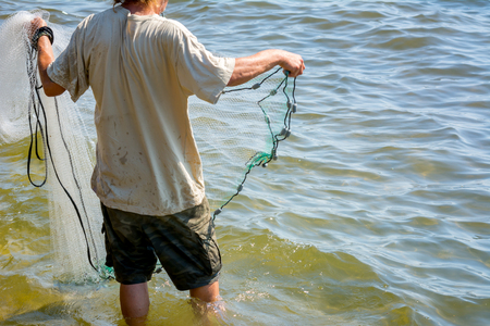 Man that Hand Launches the Fishnet at Sea on Blur Backgroundの写真素材
