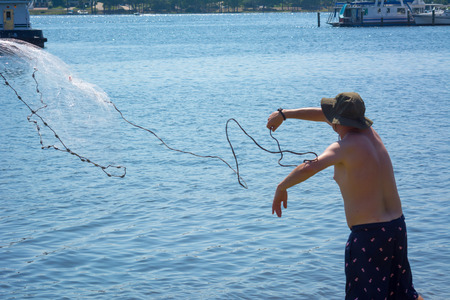 Man that Hand Launches the Fishnet at Sea on Blur Backgroundの写真素材