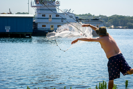 Man that Hand Launches the Fishnet at Sea on Blur Backgroundの写真素材