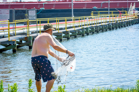 Man that Hand Launches the Fishnet at Sea on Blur Backgroundの写真素材