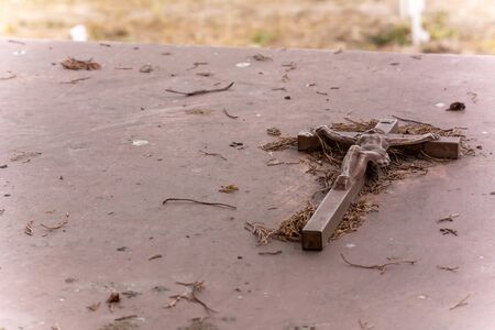 Christian Crux on Tomb Surface in the Day of Commemoration of the Dead in Italian Cemetery on Blurred Backgroundの写真素材