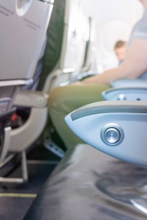 Close Up of Armrest inside an Airplane during Flight on Blurred Backgroundの写真素材
