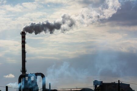Red and White Chimney Smoking on Cloudy Sky Background. Pollution in the Atmosphere
